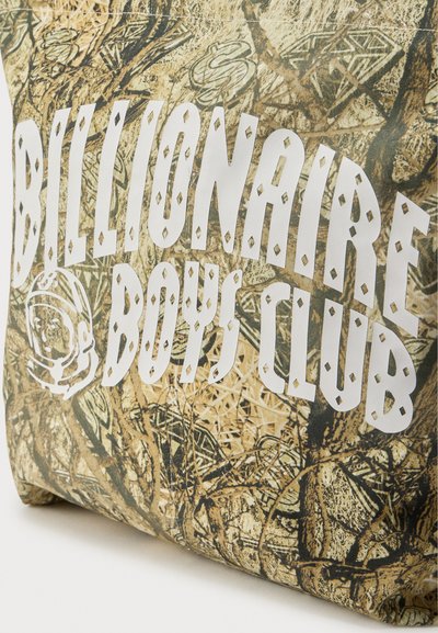 Τσάντα με καμουφλάζ μοτίβο και υφή στην επιφάνεια, με έντονα λευκά γράμματα "BILLIONAIRE BOYS CLUB" και κυκλικό λογότυπο.