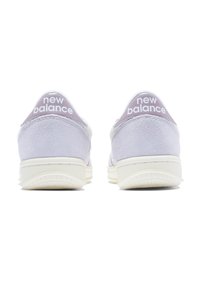 Sneaker in suede viola chiaro con suola in gomma bianca, caratterizzate da un tacco pronunciato, design arrotondato e il marchio "new balance" in bianco.
