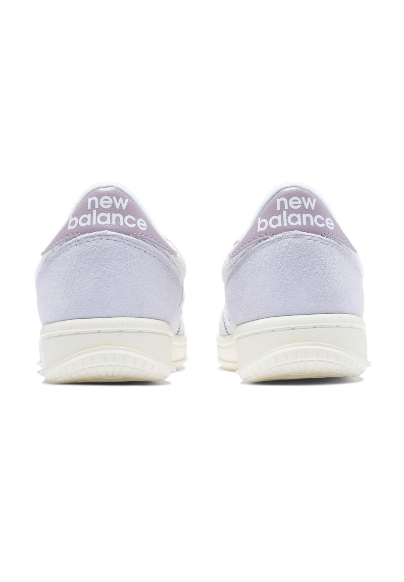 Zapatillas de ante morado claro con suela de goma blanca, que cuentan con un tacón pronunciado, diseño redondeado y la marca "new balance" en blanco.