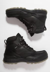 Botas de senderismo de cuero negro con un diseño de caña alta, suela de goma y acentos texturizados. Presenta ojales de metal y un cierre con cordones.