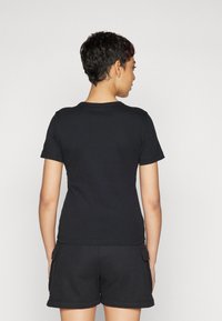 Sort kortærmet t-shirt, tætsiddende design, bomuldsstof, enkel rund halsudskæring, vist fra ryggen med matchende sorte shorts.