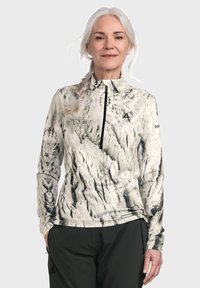 Langärmliges Oberteil mit hohem Kragen, mit einem schwarz-weißen Marmor-Muster, aus einem weichen, dehnbaren Material gefertigt. Mit einem Reißverschluss an der Vorderseite.