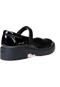 Scarpa Mary Jane in vernice nera con cinturino in velcro, punta arrotondata, suola in gomma nera chunky e logo GEox sul tallone.