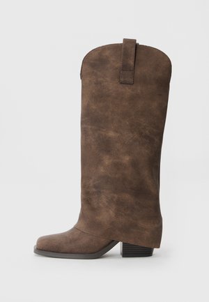Brown faux leather knee-high boots with a rounded toe, block heel, and a pull tab at the back for easy wear. Textured surface finish.