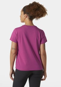Camiseta de algodón rosa con mangas cortas, escote redondo y una textura suave. Presenta un diseño simple sin patrones ni adornos.