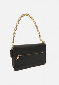 Sac en cuir noir avec une bandoulière en chaîne dorée, présentant une poche zippée à l'avant et une texture lisse. Design simple et rectangulaire avec des lignes épurées.
