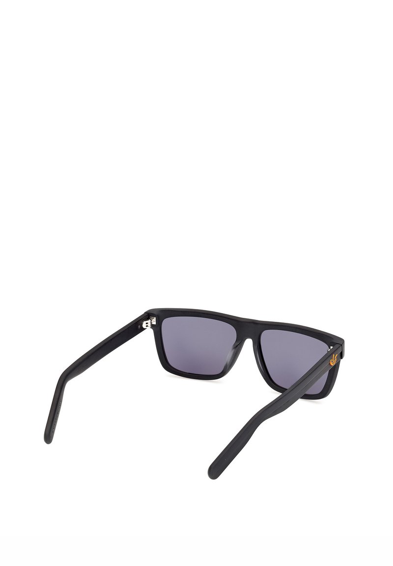 Gafas de sol rectangulares negras con lentes oscuras, patillas ligeramente anguladas y un pequeño símbolo de mano haciendo el signo de la paz en naranja en la patilla derecha.