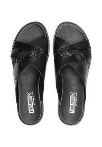 Chanclas negras de cuero suave con correas entrelazadas. Presentan una suela plana y un logo en la plantilla. Accentos texturizados a lo largo de los bordes.