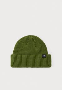 Green knitted beanie hat with a ribbed texture, folded cuff, and a small black logo label on the side.