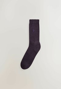 Lilla ribbede sokker med et struktureret design og en forstærket tå, med et lille logo i den øverste sektion.