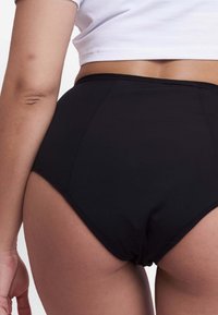 Bikini bottom nero a vita alta realizzato in tessuto morbido, con dettagli di cucitura sottili, che offre una copertura totale e un aspetto senza cuciture.