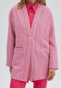 Roze en wit ruitjesblazer met een enkele knoop, een ingezakte reverskraag en twee steekzakken aan de voorkant, gemaakt van een textuurstof.