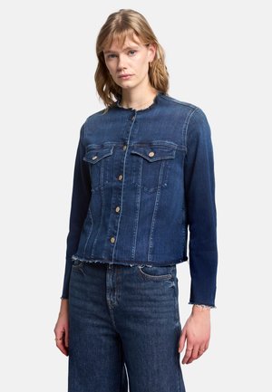 Giacca in denim blu scuro con due tasche frontali, bottoni in bronzo, orlo grezzo e maniche lunghe. Il tessuto mostra lieve texture e scolorimento.