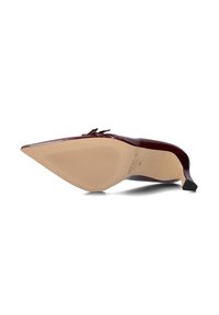 Puntige hak met een glanzende bordeaux patent leren afwerking, met een smalle hak en een gestructureerde beige zool, voorzien van een klein strikdetail op de bovenkant.