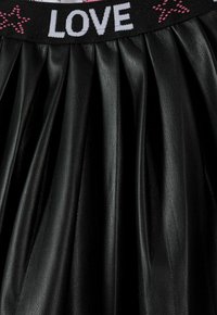 Gonna nera plissettata in ecopelle con superficie texurizzata e una vita elastica con la scritta "LOVE" in contrasto bianco e rosa.