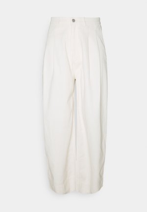 Białe spodnie o szerokich nogawkach i wysokim stanie, z plisowanym przodem i zamkiem błyskawicznym z przodu. Wykonane z bawełny o gładkiej fakturze i wykończonych nogawkach.