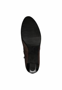 Suola di scarpa in pelle marrone con texture rigata, dotata di un leggero tacco e punta arrotondata. Accento nero lucido alla base del tacco.