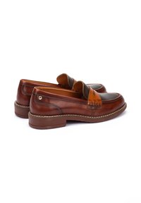 Mocasines de cuero marrón con un acabado suave, una correa naranja contrastante sobre el empeine y una suela de goma duradera.