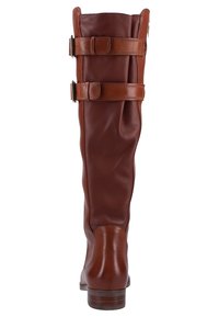 Bottes montantes en cuir marron avec deux sangles réglables et une texture lisse, dotées d'un bout arrondi et d'un talon bas empilé.