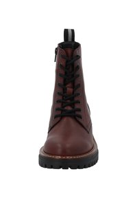 Stivali alla caviglia in pelle marrone con lacci neri, suola in gomma rialzata e un occhiello a strisce sul retro. Texture liscia e design della punta arrotondata.