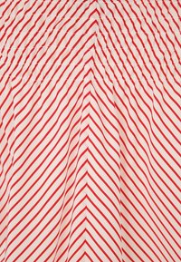 Czerwono-biała materiał w paski z elastyczną fakturą marszczoną, z diagonalnymi liniami i marszczeniem na górze.