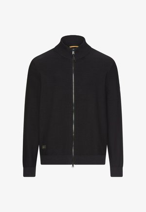 Schwarzer Pullover mit durchgehendem Reißverschluss, geripptem Stehkragen, Bündchen und Saum, mit einem kleinen rechteckigen Logo-Patch nahe der unteren linken Seite.