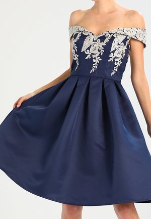 Robe bleu marine épaules dénudées avec broderie florale argentée sur le corsage et une jupe plissée évasée.