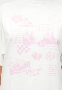 Valge T-särk roosa ekraaniprindiga graafikaga, sealhulgas tekst, lilled ja ruuduline muster, pakkudes lihtsat ja suvist kujundust.