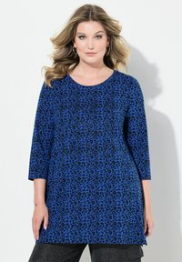 Top con stampa leopardo blu, maniche a tre quarti, scollatura tonda e delicati dettagli a trama. Il tessuto è morbido ed elastico.