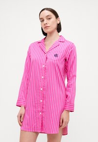 Vestido camisón de rayas rosas con mangas largas, cierre delantero con botones y bolsillo en el pecho con un logotipo bordado. Tejido suave y corte relajado.