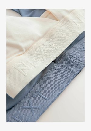 Dwa wyroby tekstylne ułożone w stos: kremowy i jasnoniebieski elastyczny materiał. Każdy z nich ma teksturowany pas z wytłoczonym w powtarzającym się wzorze napisem "NEXT".