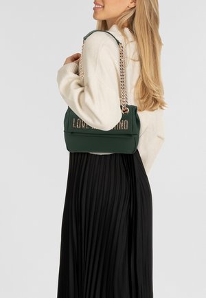 Grüne Schultertasche mit glatter Textur, versehen mit Kettendetails in Goldoptik und dem eingeprägten "LOVE MOSCHINO"-Schriftzug auf der Vorderseite.
