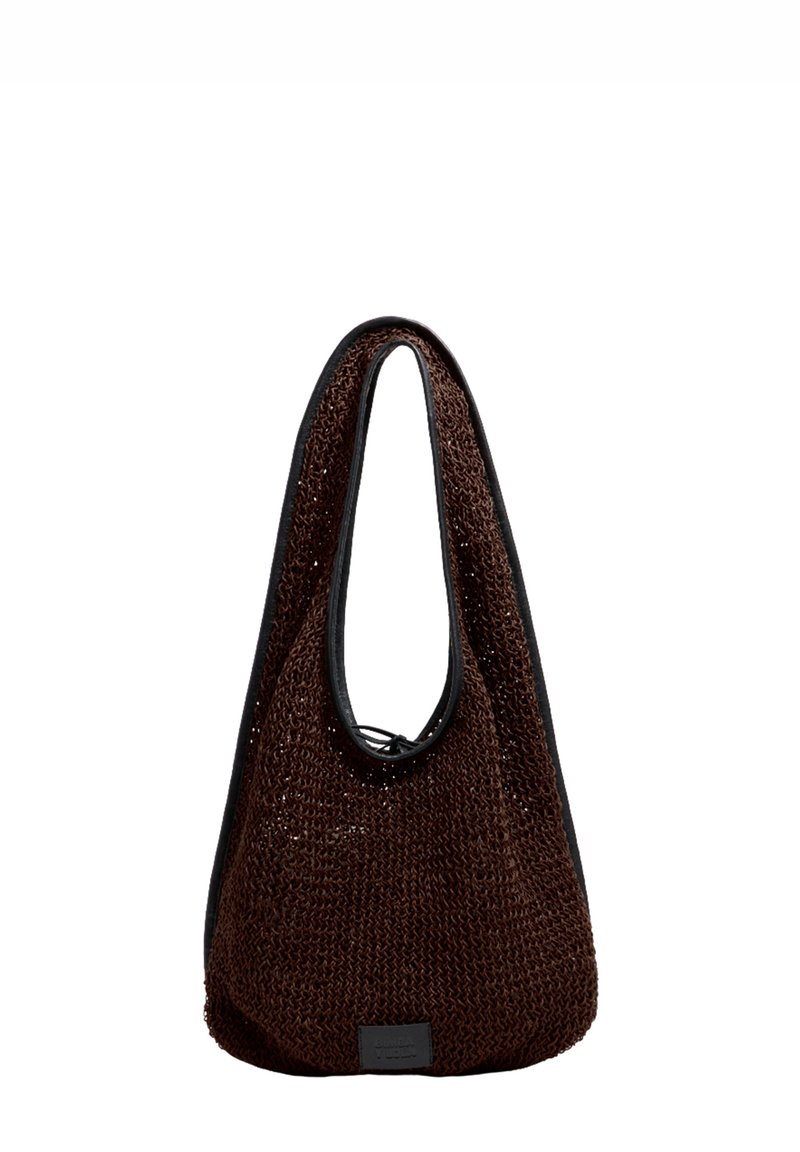 Bolso marrón tejido con textura suave, con asa de lazo y borde negro a contraste. Incluye una pequeña etiqueta en el lateral.