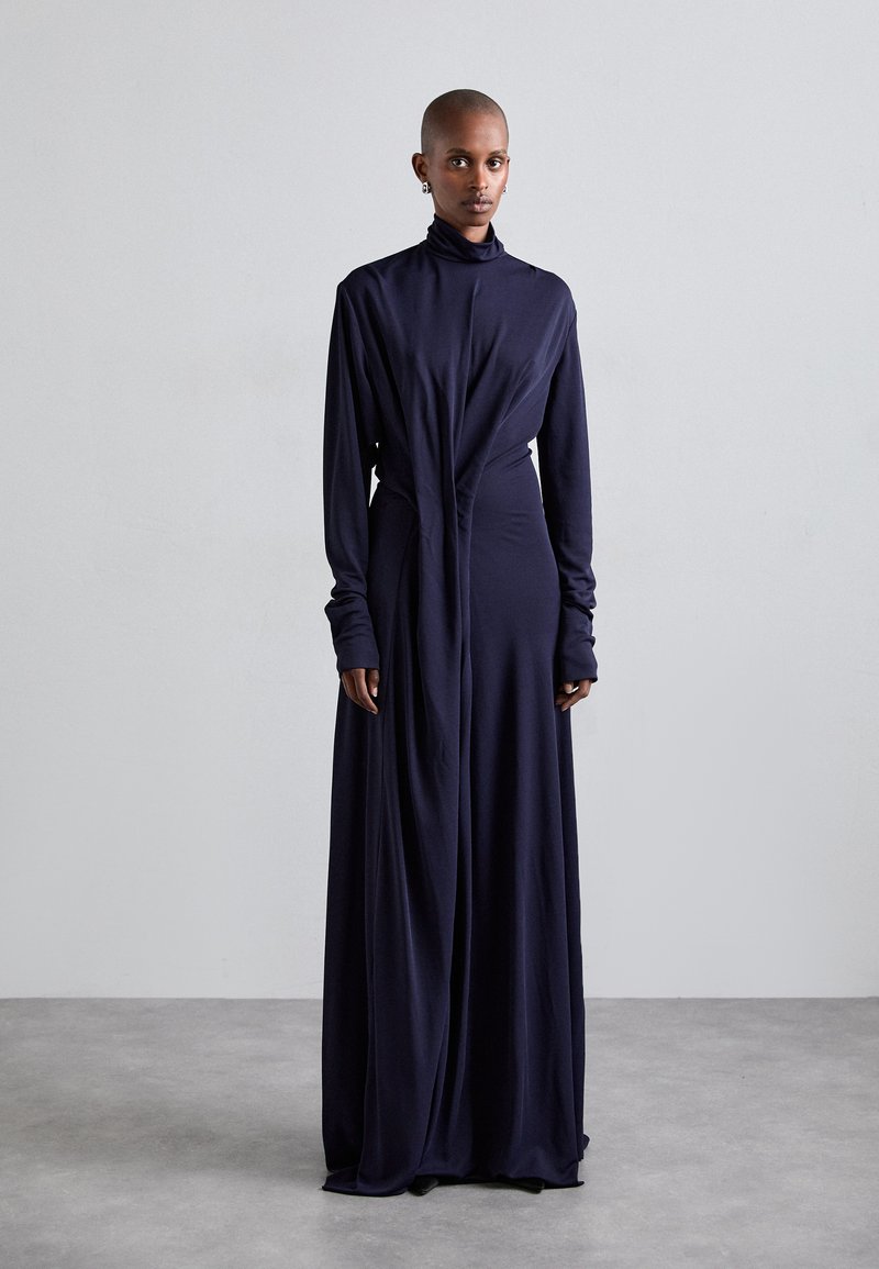 Navy long-sleeve dress with a high neck and draped front design. Made of soft fabric, features elongated sleeves and a relaxed silhouette.