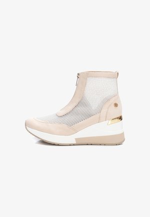 Botín de tobillo de material mixto en beige con paneles de malla, detalles de ante, cierre de cremallera y un alto tacón cuña con un acento metálico.