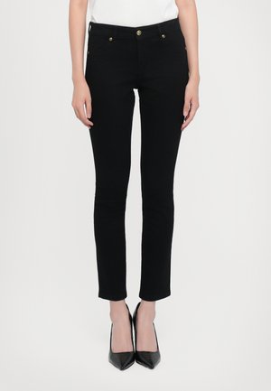 Črne ankle dolge jeans hlače iz raztegljivega denima, ki imajo ozek kroj, dve sprednji žep in zlate dodatke na pasu.