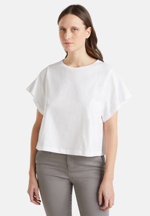 Bílý bavlněný crop top s krátkými rukávy a kulatým výstřihem, s hladkou texturou a volným střihem.