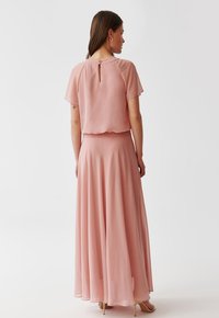 Helles pinkes Chiffonkleid mit kurzen Ärmeln, einem ausgestellten Rock und einem Schlüssel-Detail auf der Rückseite. Glatte Textur, fließendes Design.