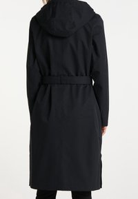 Trench-coat noir avec capuche, taille ceinturée et fentes latérales. Confectionné en tissu lisse avec une silhouette classique et un design minimaliste.