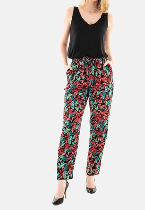 Un pantalon floral avec un arrière-plan noir vif orné de motifs de feuilles rouges et vertes, une taille élastique et des poches ; associé à un haut sans manches noir.