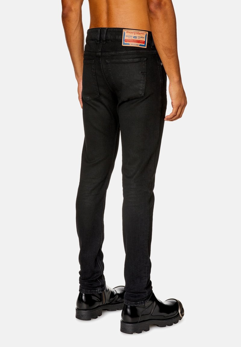 Czarne dżinsy o slim fit, standardowe kieszenie oraz skórzana naszywka z logo na tylnej talii. Matowa tekstura z minimalnym przetarciem.