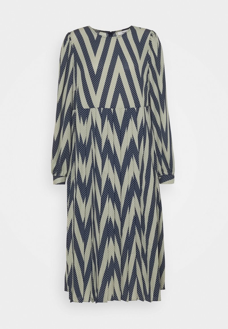 Sukienka z długim rękawem w kolorze kremowym z granatowym wzorem w zygzaki i kropki, okrągły dekolt oraz zwiewny krój.