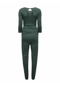 Combinaison verte avec des manches trois-quarts, taille élastique, détail en trou de serrure au dos et poignets ajustés. Fabriquée en matériau doux et extensible.