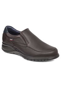 Zapato marrón de cuero tipo slip-on con un acabado suave, punta redondeada, paneles laterales elásticos y cuello acolchado para mayor comodidad. Suela de goma con líneas de agarre.