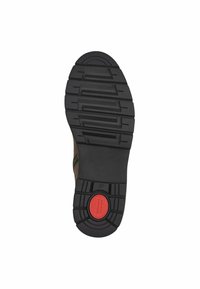 Semelle en caoutchouc avec une surface noire texturée, présentant des rainures profondes pour une adhérence optimale et un accent circulaire rouge près du talon. Taille 37 indiquée.