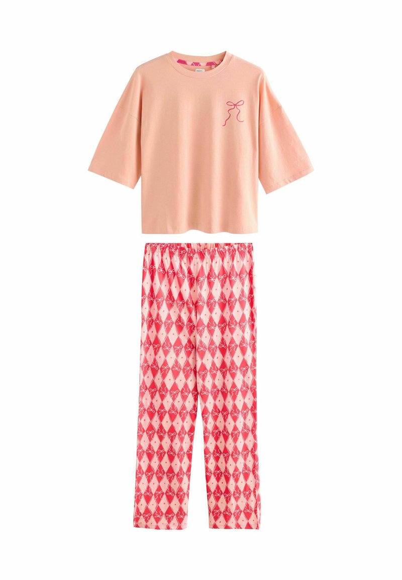 Light pink short-sleeve top with a small bow graphic; red pajama pants featuring a diamond pattern and bow designs throughout.