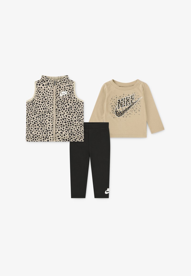 Dreiteiliges Kinderoutfit: Weste mit Leopardenmuster, beiger Langarmoberteil mit Nike-Logo und schwarze Leggings mit weißem Nike-Akzent.