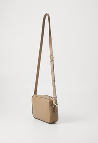 Sac bandoulière en cuir synthétique marron de forme rectangulaire, avec une sangle réglable, des accessoires en or et un bord noir contrastant le long de la fermeture éclair.
