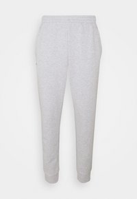 Világosszürke melegítőnadrág rugalmas derékkal, gumírozott bokákkal és puha textúrával. Minimalista dizájn jellemzi, és nincsenek látható logók vagy minták.