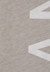 Szary materiał o fakturowanej powierzchni z białymi kątowymi kształtami. Wzór zawiera wyraźny, duży element geometryczny.